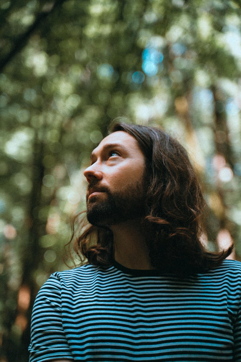 Profile photo of Justin Robinson--a man with medium-length brown hair and a black and white striped shirt.